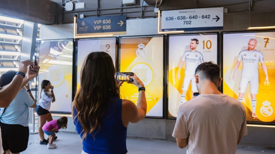 Visitors snap photos and interact with the display as they move through the Realmadrid Games digital experience